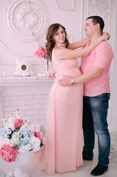 Family waiting for baby\'s birth. A pregnant woman and her husband wearing white clothing