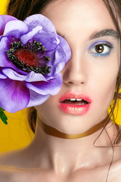 Beauty Girl Portrait with Vivid Makeup. Fashion Woman portrait close up on yellow background. Bright Colors. Manicure Make up. Smoky eyes, long eyelashes. Rainbow Colors. Retouched shot