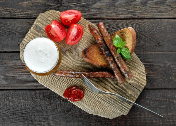 Sausages with tomatos and beer, top view