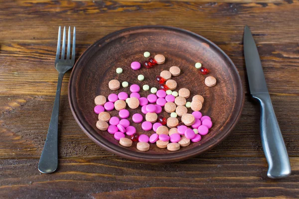 Pills on a plate with knife and fork