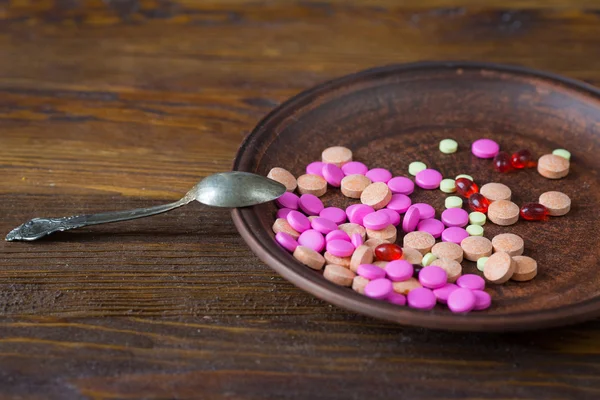 Pills on a plate with a spoon
