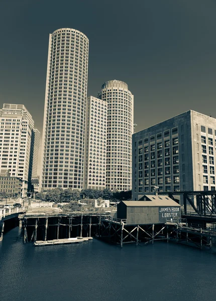 Boston, Massachusetts - June 2016, USA: View of One International Place Skyscraper, US Coast Guard building and James Hook Lobster House in Boston Harbor (Waterfront)