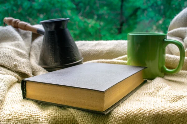 Cup of tea and a book on the window.