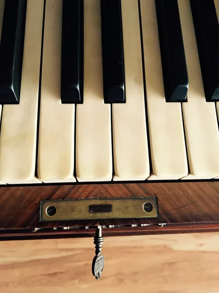 Closeup of old wooden piano with ivory keys