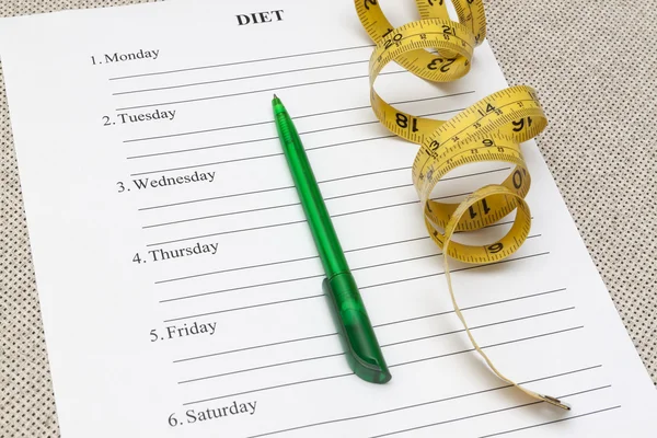 Paper blank diet plan, pen and yellow measure tape