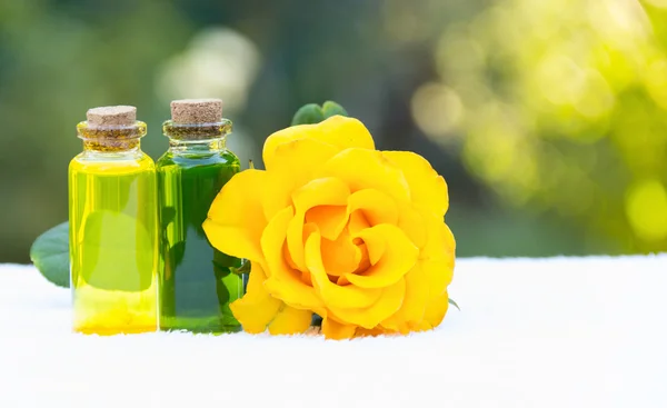 Essential oils for aromatherapy. Rose oil and green elixir. Useful Natural cosmetics. Cosmetics for saunas and spa treatments. Spa concept. Fragrant yellow rose. Copy space.