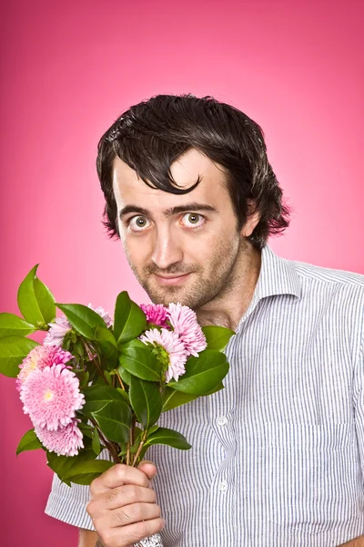 Funny psychopathic nerd with flowers isolated on pink