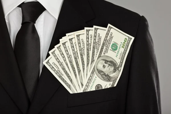 Satisfied and happy businessman keep dollar money in pocket suit