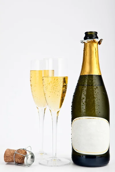 Champagne gold bottle with glasses isolated on grey