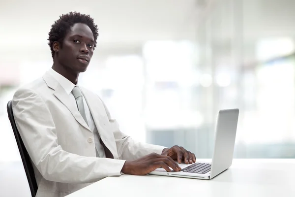 Handsome black businessman with white suit in a interior background