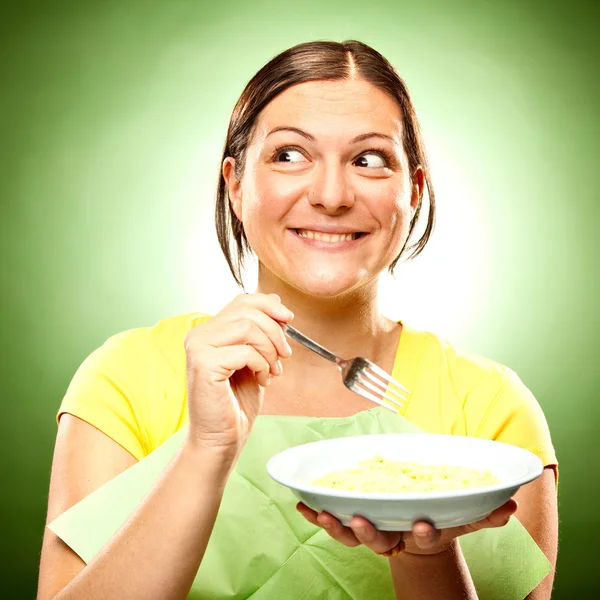 Funny smiling girl eat standing with green background