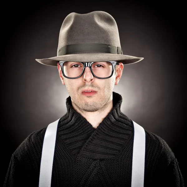 Young man nerd with hat and glasses on black background