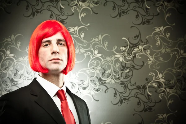 Businessman with colored tie and hair wig on tapestry background