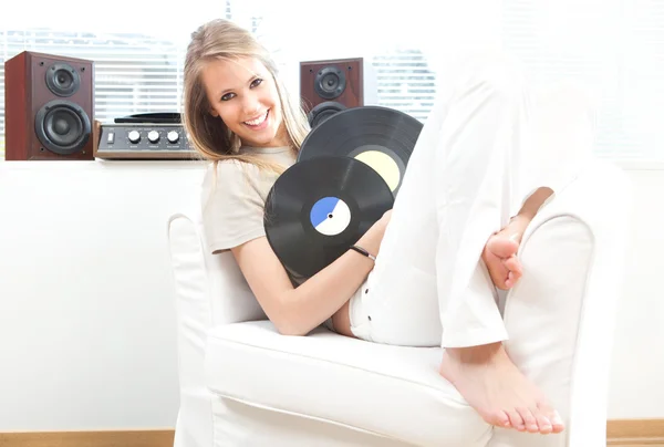 Young beautiful woman listen music with record in a living room