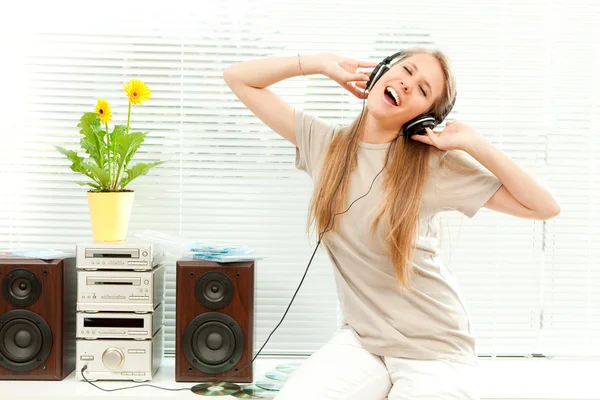 Young beautiful woman listen music with headphone in a living room