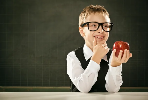 Young clever student think with apple and blackboard
