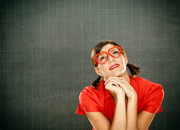 Sensual dreamy young student red dressed with glasses and blackboard