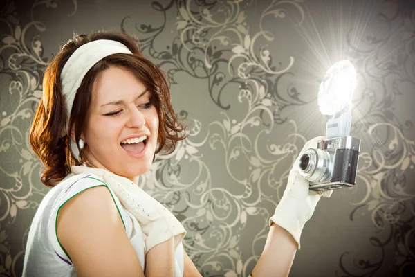 Beautiful vintage girl take photograph with old camera on tapestry background