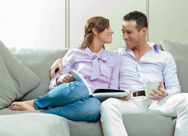 Young happy couple relax on couch at home