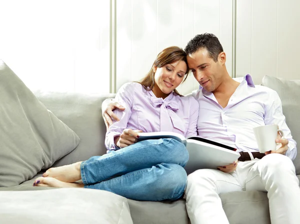 Young happy couple relax on couch at home