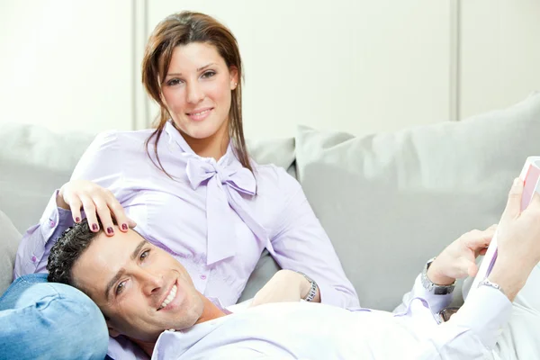 Young happy couple relax on couch at home