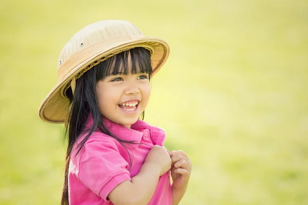 Happy asian smiling child with hat play in a garden