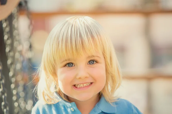 Happy smiling blond child play in the park