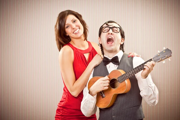 Nerd boyfriend man in love with beautiful woman play a serenade song with ukulele for Valentine Day