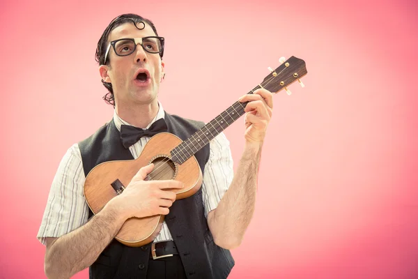 Nerd man with glasses play music with ukulele guitar