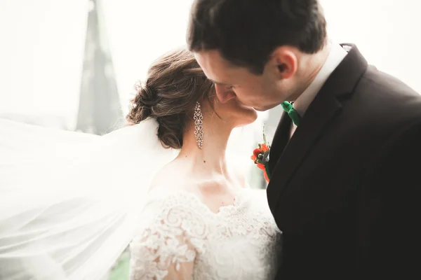 Beautiful wedding couple newlyweds standing on balcony with a view of the city