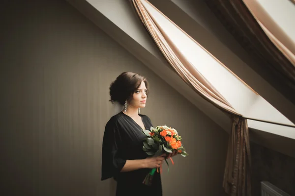 Luxury bride in black robe posing while preparing for the wedding ceremony