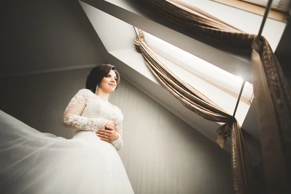 Luxury bride in white dress posing while preparing for the wedding ceremony