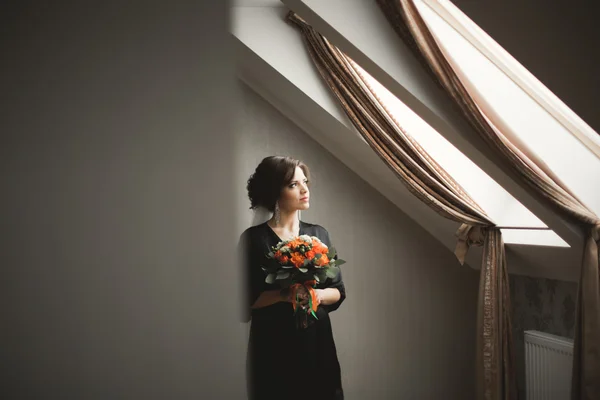 Luxury bride in black robe posing while preparing for the wedding ceremony