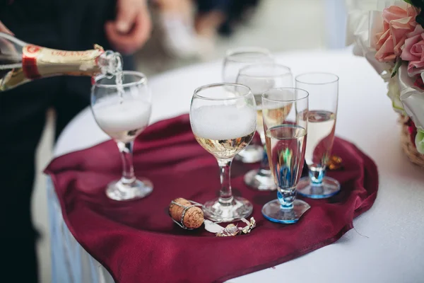 Different alcohol drinks in goblets and wine glasses on wedding buffet table