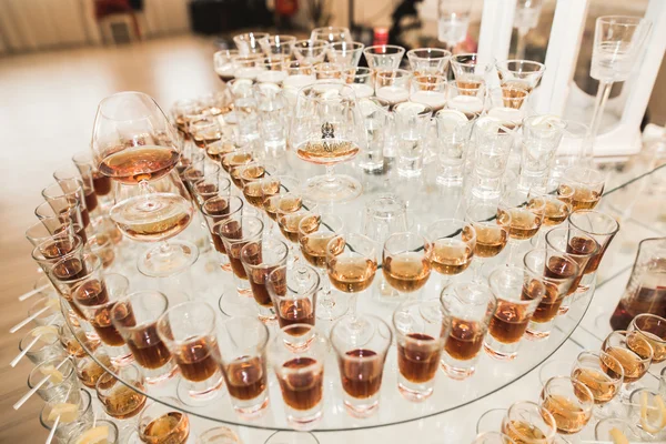 Different alcohol drinks in goblets and wine glasses on wedding buffet table