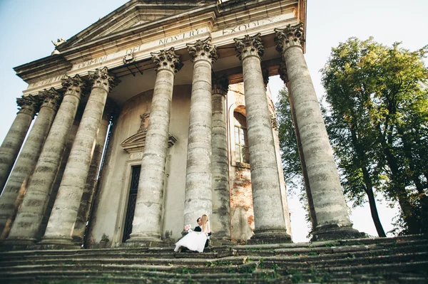 Beautiful romantic wedding couple of newlyweds hugging near old castle