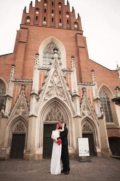 Bride and groom on the background of beautiful church. Beautiful old building. Arch. Wedding
