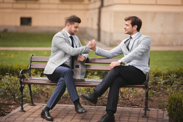 Two stylish businessmen shaking hands in suits