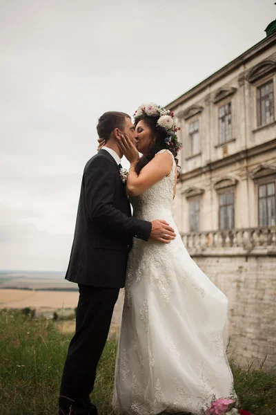 Happy wedding couple hugging and kissing on background old castle