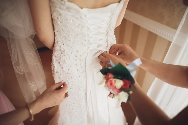 Luxury bride in white dress posing while preparing for the wedding ceremony