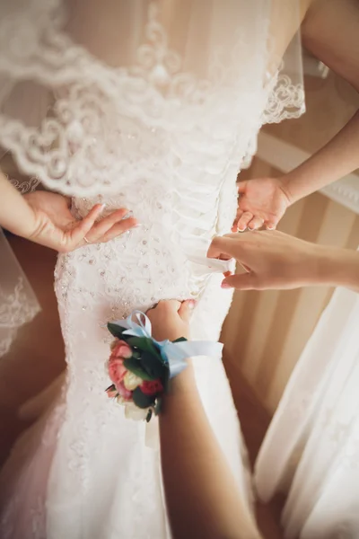 Luxury bride in white dress posing while preparing for the wedding ceremony