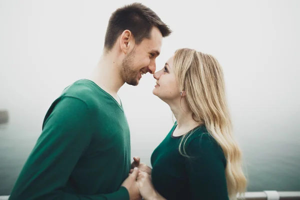 Lovely couple kissing and hugging on a sea dock