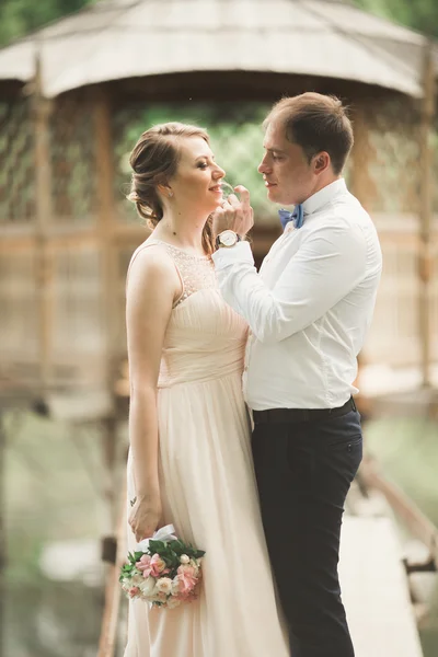 Groom kisses brides forehead while she leans to him smiling