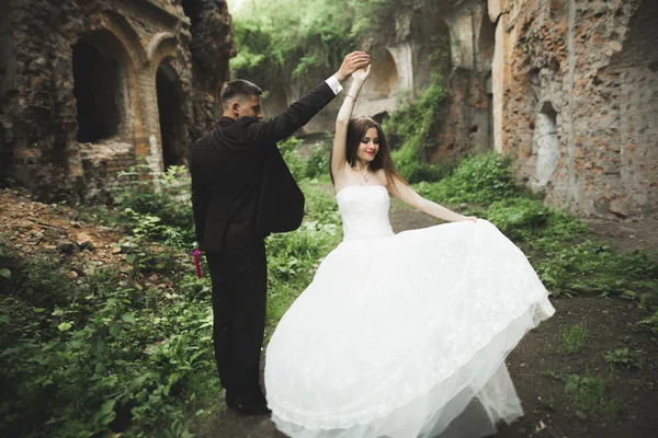 Just married poses and kissing with an old fortress on the background