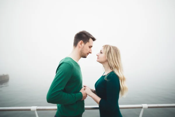 Lovely couple kissing and hugging on a sea dock