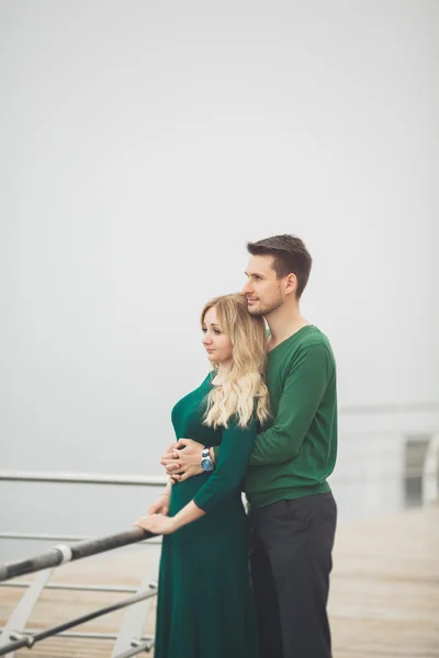 Lovely couple kissing and hugging on a sea dock