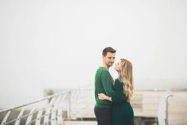 Lovely couple kissing and hugging on a sea dock