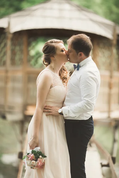 Groom kisses brides forehead while she leans to him smiling