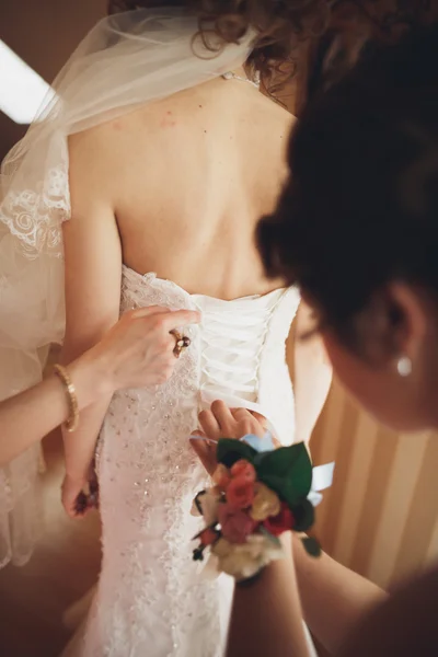 Luxury bride in white dress posing while preparing for the wedding ceremony