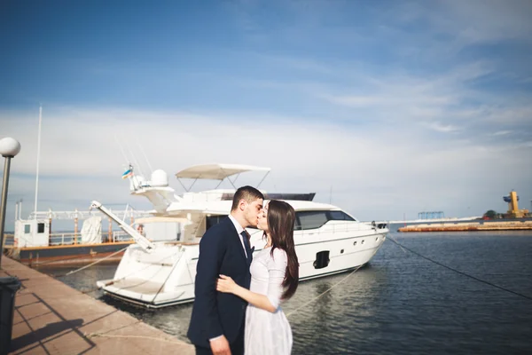 Happy wedding couple hugging near new yacht
